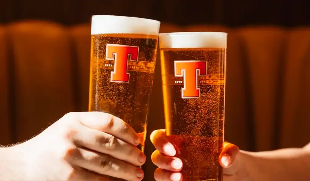 cerveza tennents con amigos en un bar