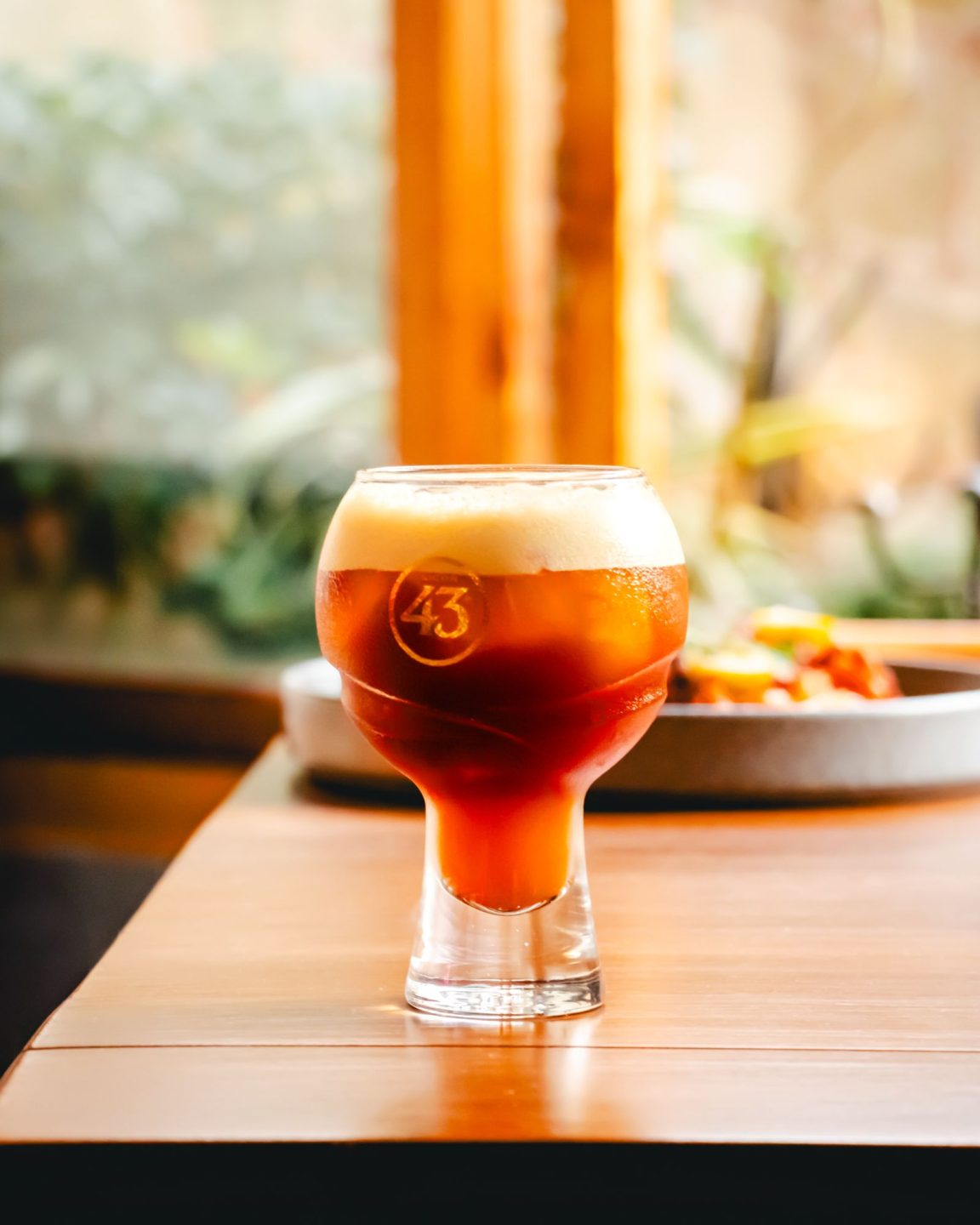 Vaso de cerveza artesanal en copa tulipa sobre una barra